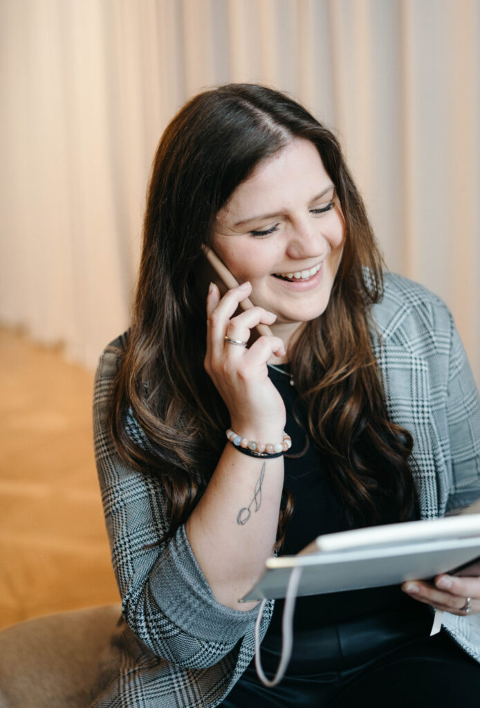 Hochzeitsplanerin Laura Kohlbacher telefoniert mit einer Braut und macht mit ihr einen weiteren Planungstermin aus.